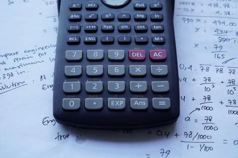 Scientific math workout. sheet paper with solving equation math next to calcu Stock Photos