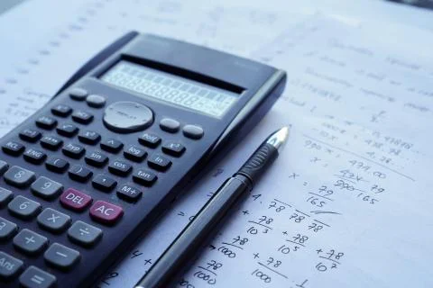 Scientific math workout. sheet paper with solving equation math next to calcu Stock Photos