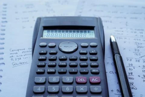 Scientific math workout. sheet paper with solving equation math next to calcu Stock Photos