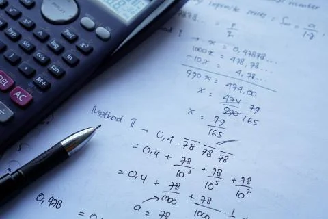 Scientific math workout. sheet paper with solving equation math next to calcu Stock Photos