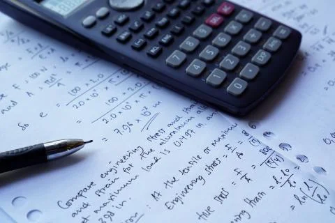 Scientific math workout. sheet paper with solving equation math next to calcu Stock Photos