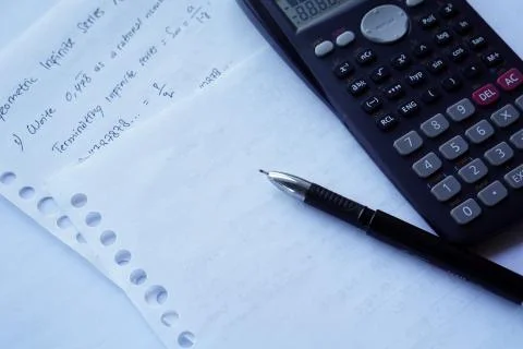 Scientific math workout. sheet paper with solving equation math next to calcu Stock Photos