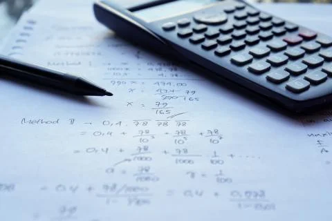 Scientific math workout. sheet paper with solving equation math next to calcu Stock Photos