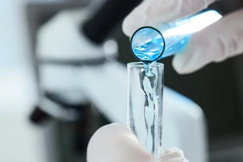 Scientific research and development with blue liquid pouring into test tube i Stock Photos