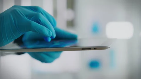 A scientific research expert in protective suit looks carefully at the touch Stock Footage 262276308