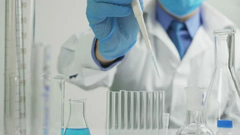 Scientific researcher dosing solution with pipette for study in the lab Stock Footage 196108933