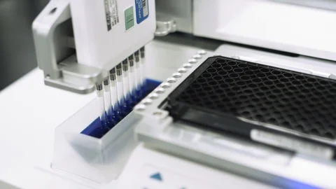 Scientifically measuring blue liquid to test samples for virus in a lab Stock Footage 127533189