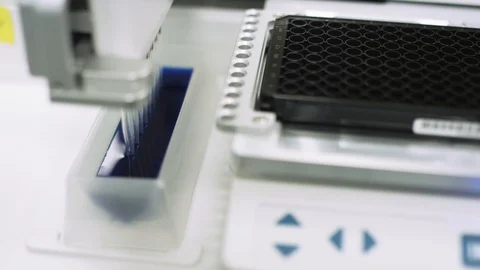 Scientifically measuring blue liquid to test samples for virus in a lab Stock Footage 127533200