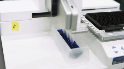 Scientifically measuring blue liquid to test samples for virus in a lab Stock Footage 127533294