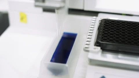 Scientifically measuring blue liquid to test samples for virus in a lab Stock Footage 127533420