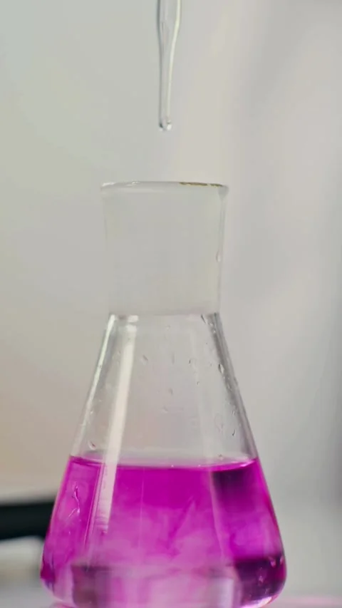 Scientist adding chemical drop to pink liquid in flask Vídeos de archivo 331774865