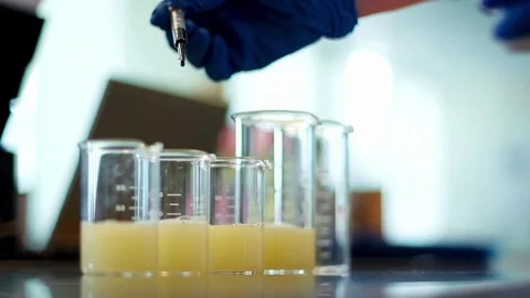 Scientist Adding Drops of Liquid Into Beakers in Laboratory Close Up 動画素材 332600738