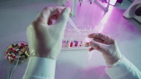 Scientist adding liquid with pipette in test tube during medical research Stock Footage 306586617