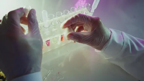 Scientist adding liquid to test tubes in laboratory Stock Footage 306588506