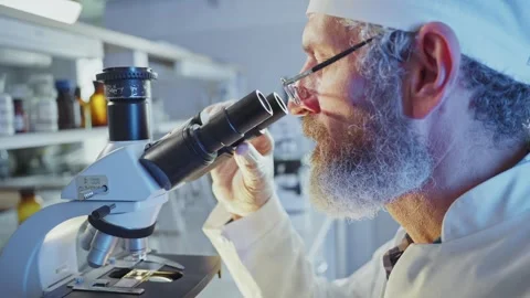 Scientist adjusting microscope, conducting pharmaceutical research in laboratory Stock Footage 304888001