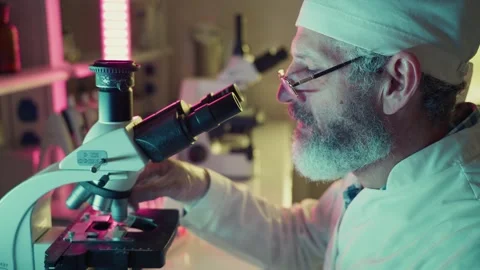 Scientist adjusting microscope, conducting research in laboratory Stock Footage 304892357