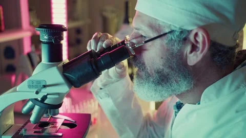 Scientist adjusting microscope, conducting research in laboratory Stock Footage 306584708