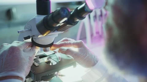 Scientist adjusting microscope slide in laboratory Stock Footage 306594926
