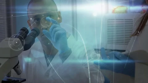 Scientist adjusting microscope while colleague showing sample, graphics tracking Stock Footage 331634576