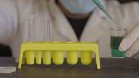 Scientist analysing a green sample of liquid, closeup. Medical research concept Stock Footage 153043331