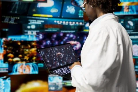Scientist analyzing 3D virus structure on laptop to support vaccine development Stock Photos