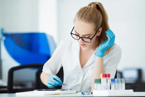 Scientist analyzing microscope slide at laboratory. Female Working in Laboratory Stock Photos