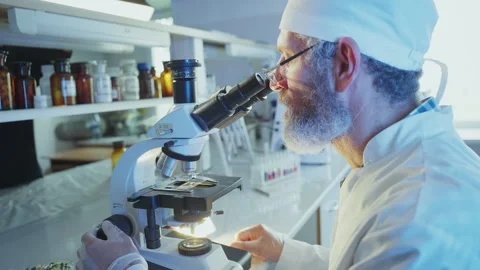 Scientist analyzing sample with microscope in laboratory Stock Footage 306584603
