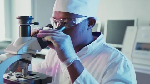 Scientist analyzing sample with microscope in laboratory Stock Footage 306588592