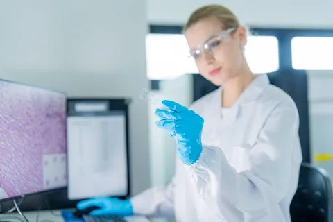 Scientist analyzing samples in laboratory setting while using computer for .. 스톡 사진