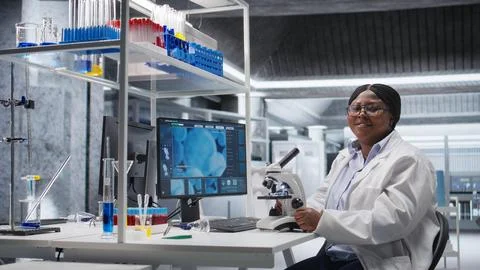 Scientist analyzing samples in laboratory setting with microscope and chemicals 스톡 사진