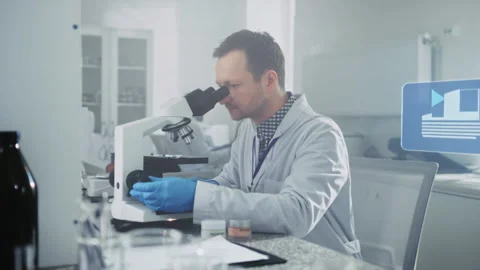 Scientist Analyzing Samples Under Microscope in Laboratory Stock Footage 319494230