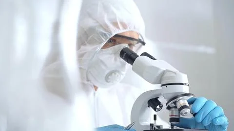 Scientist is analyzing samples using a microscope in a laboratory setting. Close Stock Photos