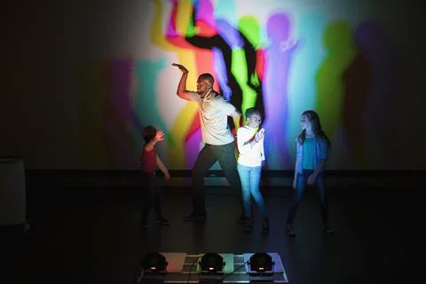 Scientist and children casting multicolor shadows on projection screen in scienc Foto stock