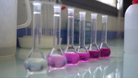 Scientist Arranging Volumetric Flasks Showing Acid-Base Titration Color Gradient Vídeos de archivo 334617874