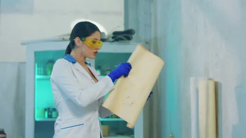 Scientist attractive female using the paper sheet of notes to end her experiment Stock Footage 153081964
