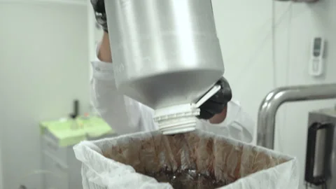 Scientist with black gloves working on complex machine and pouring Hemp oil into Stock Footage 160900701