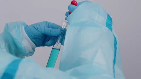 Scientist in Blue PPE Using Pipette to Add Liquid to Test Tube 库存影片 335136976