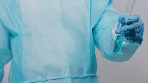 Scientist in Blue Protective Suit Inspects Test Tube with Liquid Vídeos de archivo 335136785