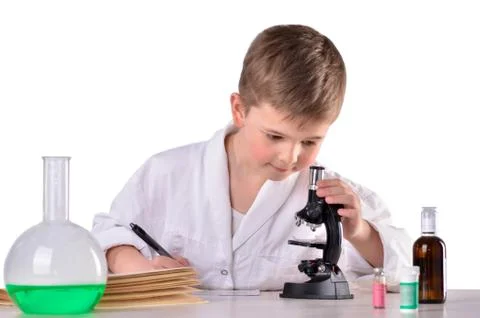 Scientist boy at the desk in the lab write research results Stock Photos
