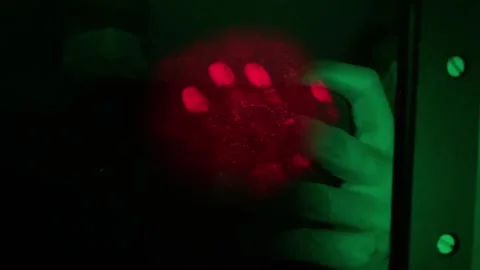 Scientist checking a luminescent handprint on a phosphorescent screen 스톡 동영상 320815731