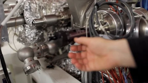 Scientist checking the Particles Accelerator machine in a vacuum laboratory.	 Stock-Footage 129358095