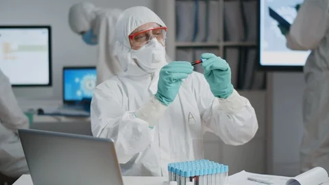 Scientist in chemical protective suit testing blood into test tube at laboratory Video stock 127508973