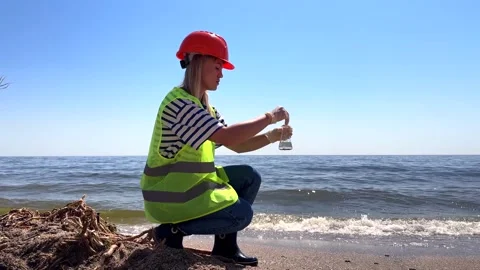 Scientist collects water samples along the shoreline Vídeos de archivo 337452218