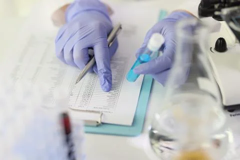 Scientist compares results of research to data in paper Stock Photos