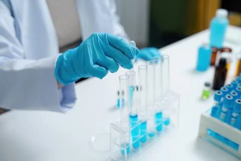 Scientist Conducting Experiment with Test Tubes in Laboratory Wearing Blue Stock Photos