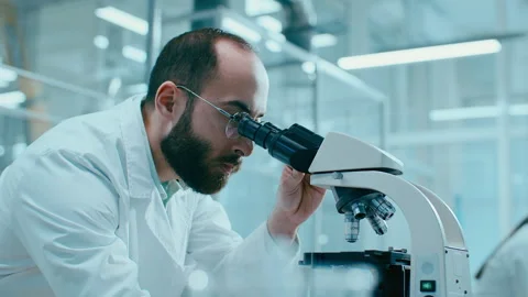Scientist Conducting Microscopic Research in Advanced Laboratory Stockbeeldmateriaal 331336887