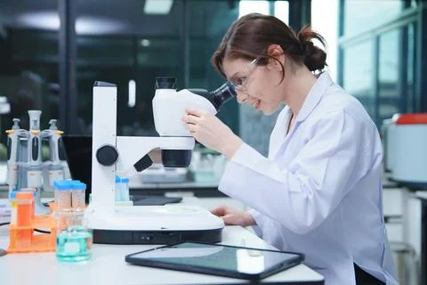 Scientist Conducting Research with Microscope in Laboratory Fotos de archivo