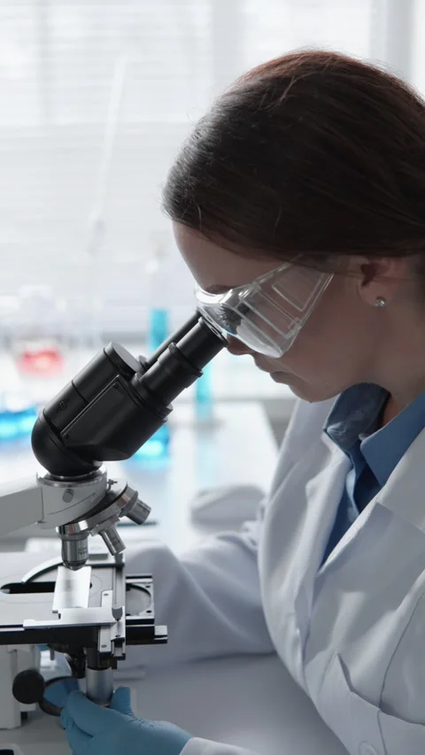 A scientist is conducting research with a microscope in a modern laboratory Stock Footage 283207656