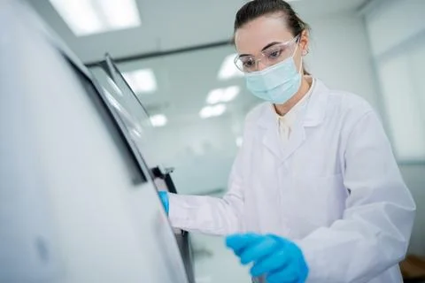 Scientist conducts experiment in laboratory during work hours in modern res.. Stockfoto's
