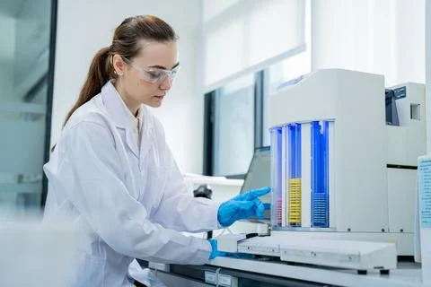 Scientist conducts experiments in laboratory with a machine and samples dur.. Stock Photos